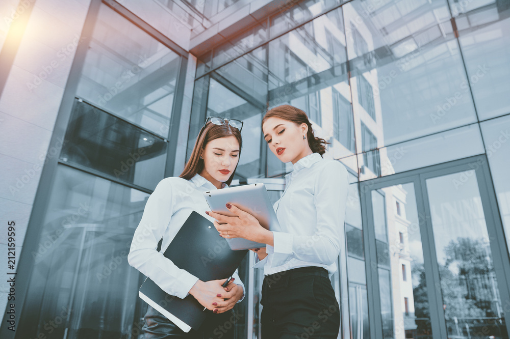 Business lady. Office staff. Two young girls with electronic tab Business lady. Office staff. Two young girls with electronic tab