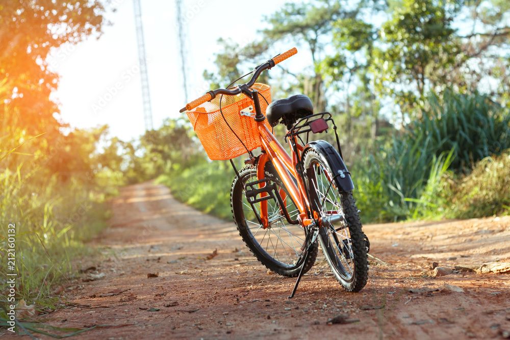 Fototapeta premium Bicycle on the dirt road at sunset