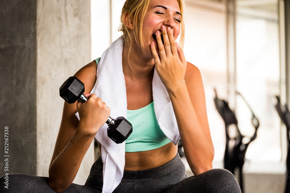 Attractive young woman exercising building muscles at the gym