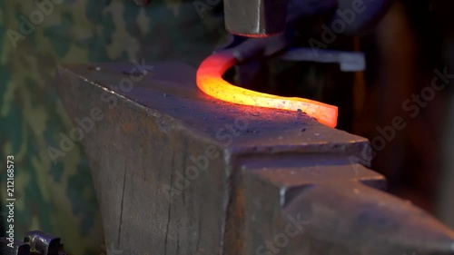 UHD closeup of a blacksmith forging the horseshoe with his hammer