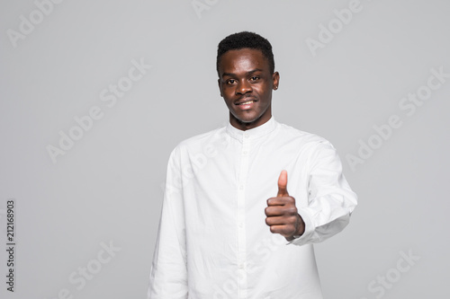 Young happy African man giving thumbs up isolated on gray background