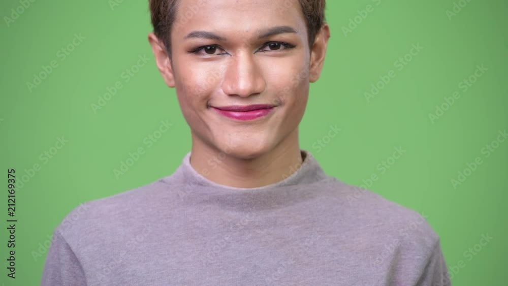 Happy young androgynous Asian man smiling Happy young androgynous Asian man smiling