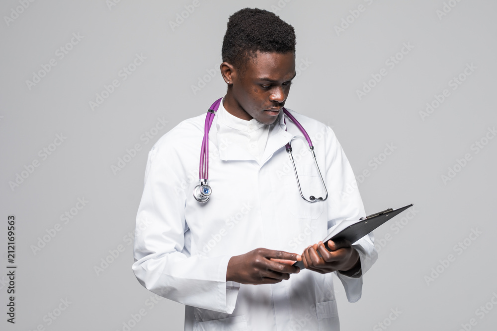 Friendly Afro-American doctor holding a clipboard and smiling at the camera isolated on gray background Friendly Afro-American doctor holding a clipboard and smiling at the camera isolated on gray background