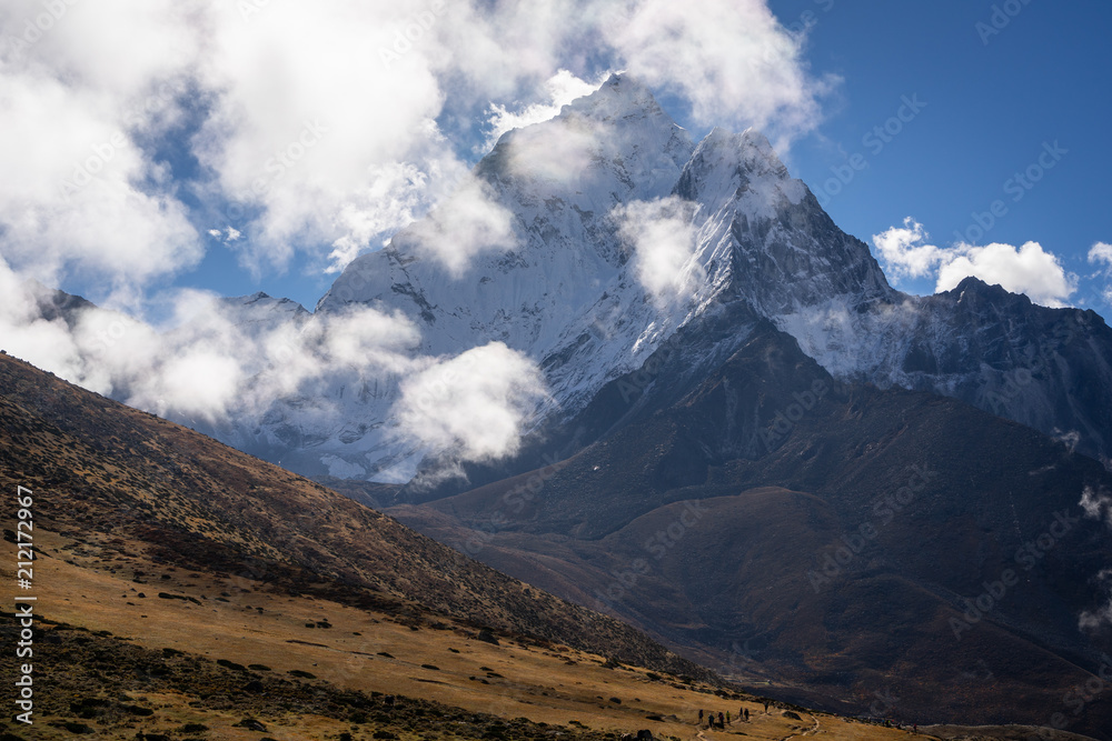 Ama Dablam mountain peak behind trekkers in Everest region trekking, Nepal