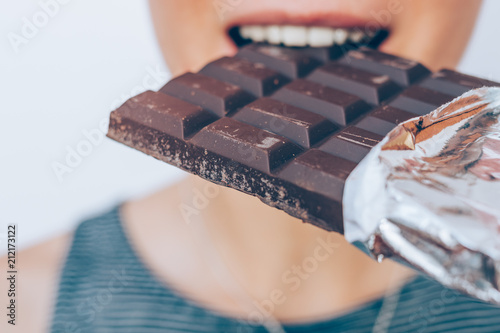 Close-up of young woman eating a chocolate bar