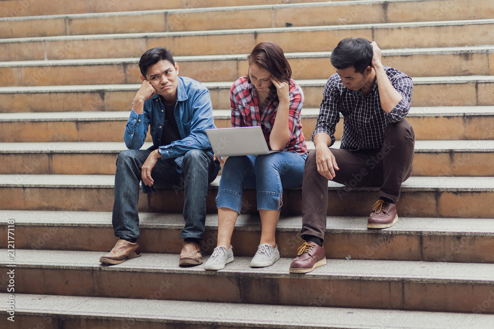 Fototapeta premium group of people thinking about work with laptop and sit outdoor on steps