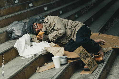 Potrait of homeless people sleeping with help paper sign