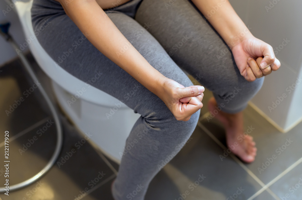 Woman sitting in toilet and suffering from constipation after wake up in morning