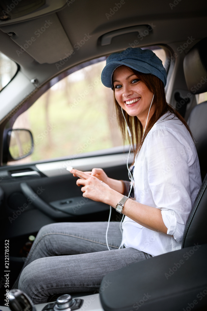 Woman in car holding cell phone