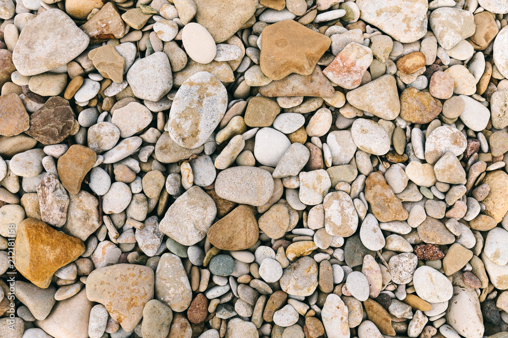 Flatlay view rounded sea pebble stones and multicolor rocks on beach Flatlay view rounded sea pebble stones and multicolor rocks on beach