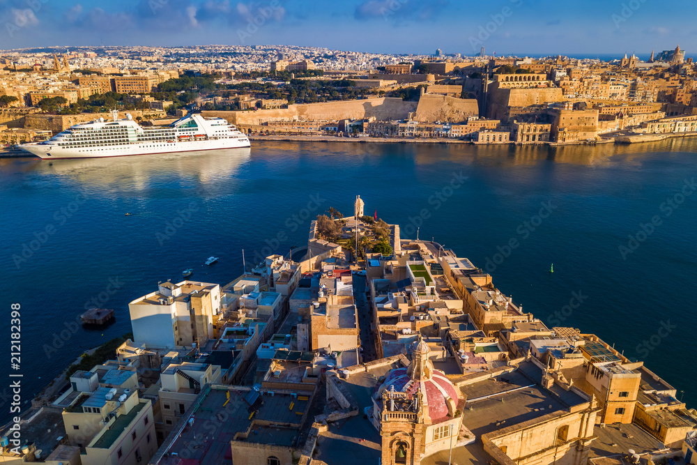 Valletta, Malta - Aerial view of Senglea, Gardjola Gardens, Saluting Battery, Upper Barrakka Gardens and Grand Harbor with Cruise ship at sunrise
