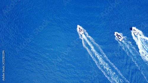 Aerial birds eye view from drone of speed boats cruising in deep blue sea