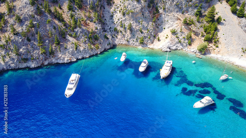 Aerial birds eye view photo taken by drone of famous tropical rocky beach of Agios Georgios with yachts docked, Symi island, Dodecanese, Greece