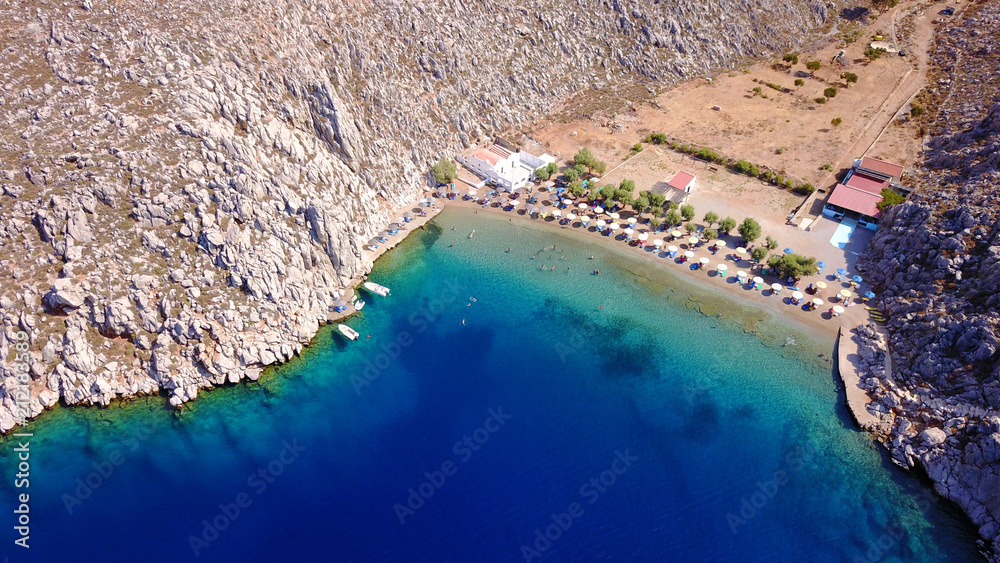 Aerial bird's eye view photo taken by drone of famous tropical rocky beach of Agios Nikolaos with clear turquoise waters, Symi island, Dodecanese, Greece