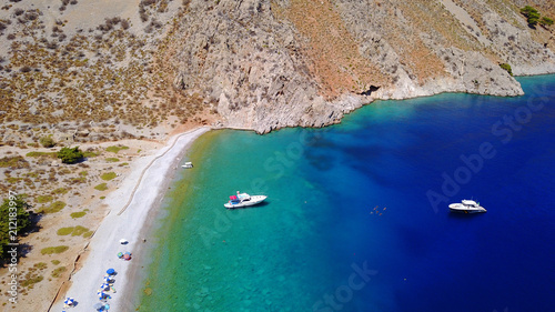 Aerial birds eye view photo taken by drone of famous tropical rocky beach of Nannou with yachts docked and clear turquoise waters, Symi island, Dodecanese, Greece photo