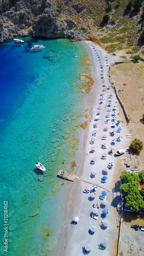 Aerial birds eye view photo taken by drone of famous tropical rocky beach of Nannou with yachts docked and clear turquoise waters  Symi island  Dodecanese  Greece