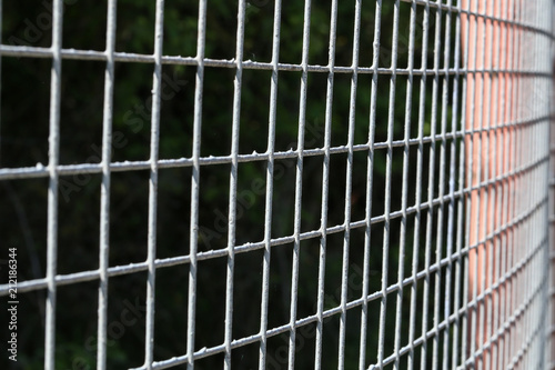 Closeup of grey mesh fence © leomalsam