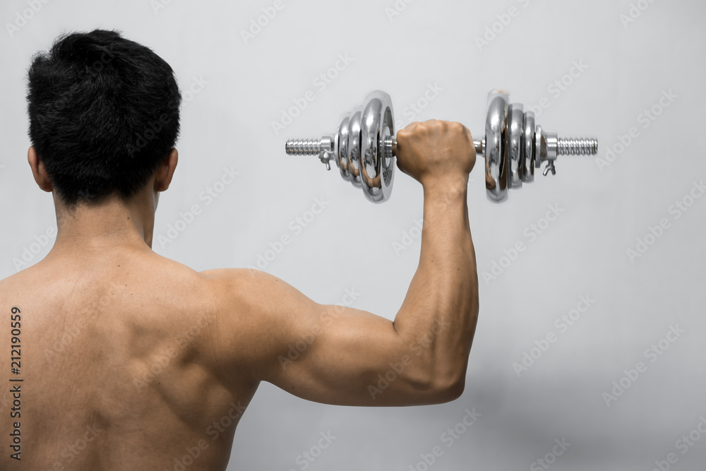 Strong man working out with dumbbell, Hand holding chrome dumbbell isolated on grey background