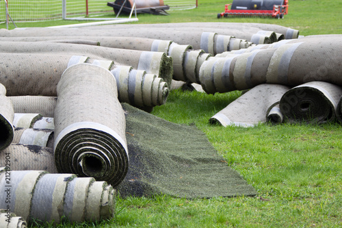 Old artificial lawn twisted into rolls photo