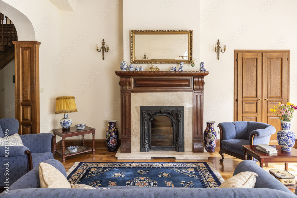 © Photographee.eu - Mirror in gold frame above fireplace in sophisticated living room interior of english house. Real photo © Photographee.eu - Mirror in gold frame above fireplace in sophisticated living room interior of english house. Real photo