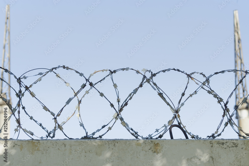 Barbed wire and blue sky in the background. Close-up Barbed wire and blue sky in the background. Close-up