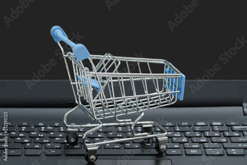 Small grocery cart on the laptop keyboard. Concept