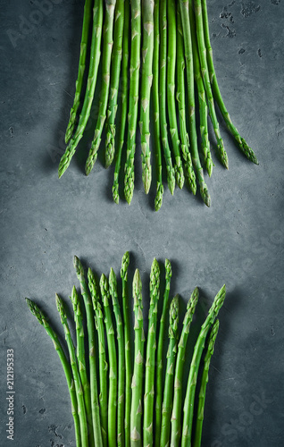 two bunches of asparagus on dark concrete background