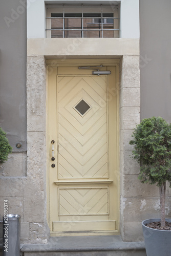 Entrance to the building. Wooden door with a rhombic window. Exterior