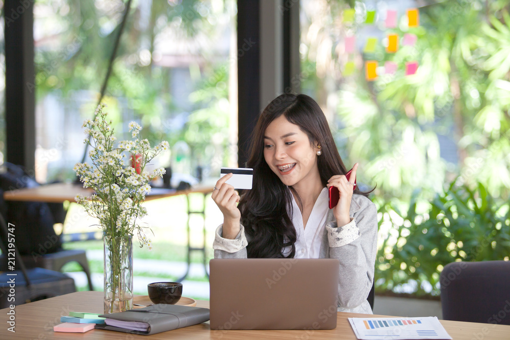 Young Asia woman holding credit card and using laptop computer. Online shopping concept Young Asia woman holding credit card and using laptop computer. Online shopping concept