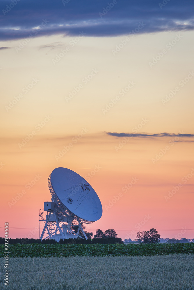 Colorful sunset sky over radiotelescope antenna at astronomy observatory, Piwnice, Torun, Poland