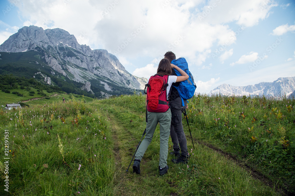 Young couple with backpacks walking on mountain