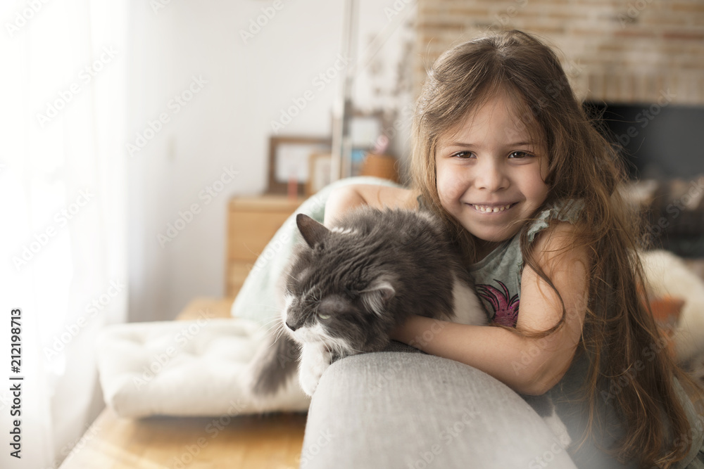 little girl and cat at home on the couch. A happy child and a pet. Copy space little girl and cat at home on the couch. A happy child and a pet. Copy space