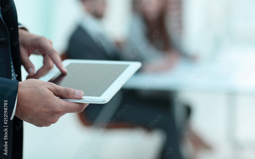 closeup.the man in the tablet on the background of the office