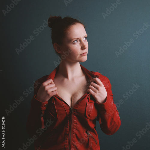 perky young busty woman wearing red vintage leather jacket showing cleavage