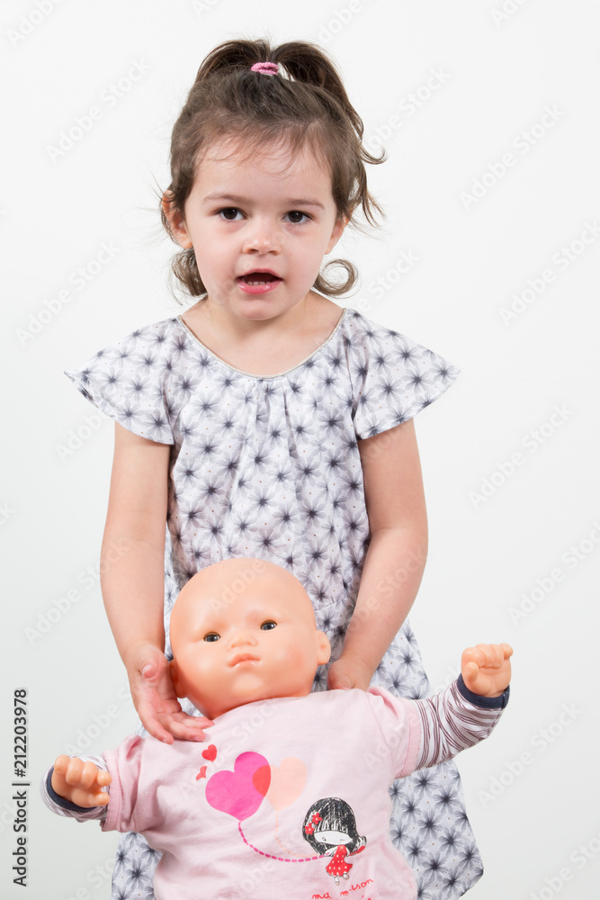 Pretty girl playing with doll Isolated on white background Pretty girl playing with doll Isolated on white background