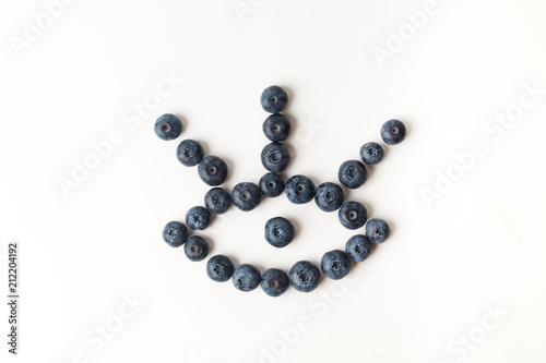 Eye with three eyelashes of blueberries on white background
