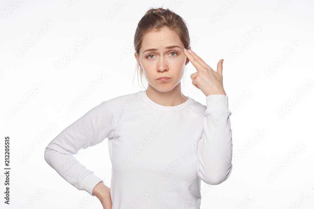 Displeased European blond female has blond messy hair, pretends killing herself, shoots in temple with fingers, curves lips, wears casual clothing, feels tired of everything, needs good rest and calm. Displeased European blond female has blond messy hair, pretends killing herself, shoots in temple with fingers, curves lips, wears casual clothing, feels tired of everything, needs good rest and calm.