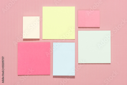 top view of empty colorful stick it notes on pink © LIGHTFIELD STUDIOS