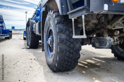 Truck in the sand, wheel close-up, construction. Traces from the truck on the sand.