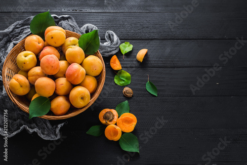 Sweet ripe apricots on black wooden background. Copy space