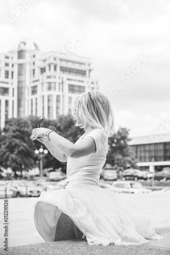 Beautiful woman feeling happy outdoors. City life urban young happy people behavior. The woman wears pleated  flutters skirt.   © T.Den_Team