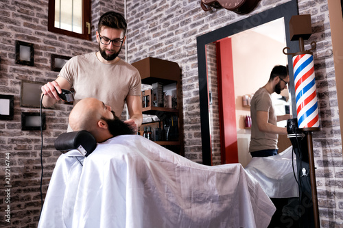 Master makes beards correction with trimmer photo