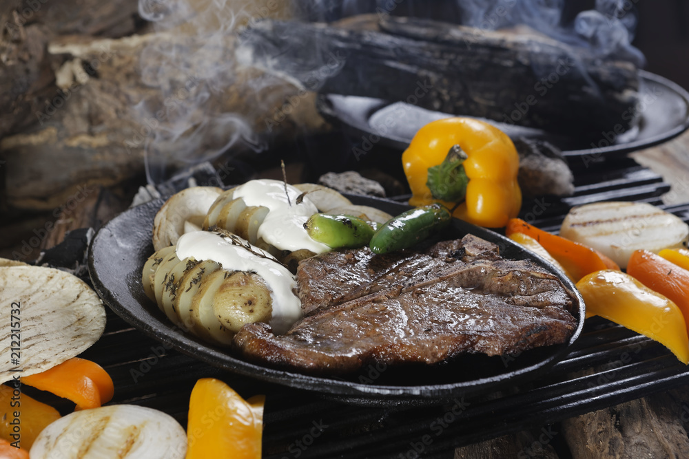 Tbone steak grilled with baked potatoes and chiles The Tbone and