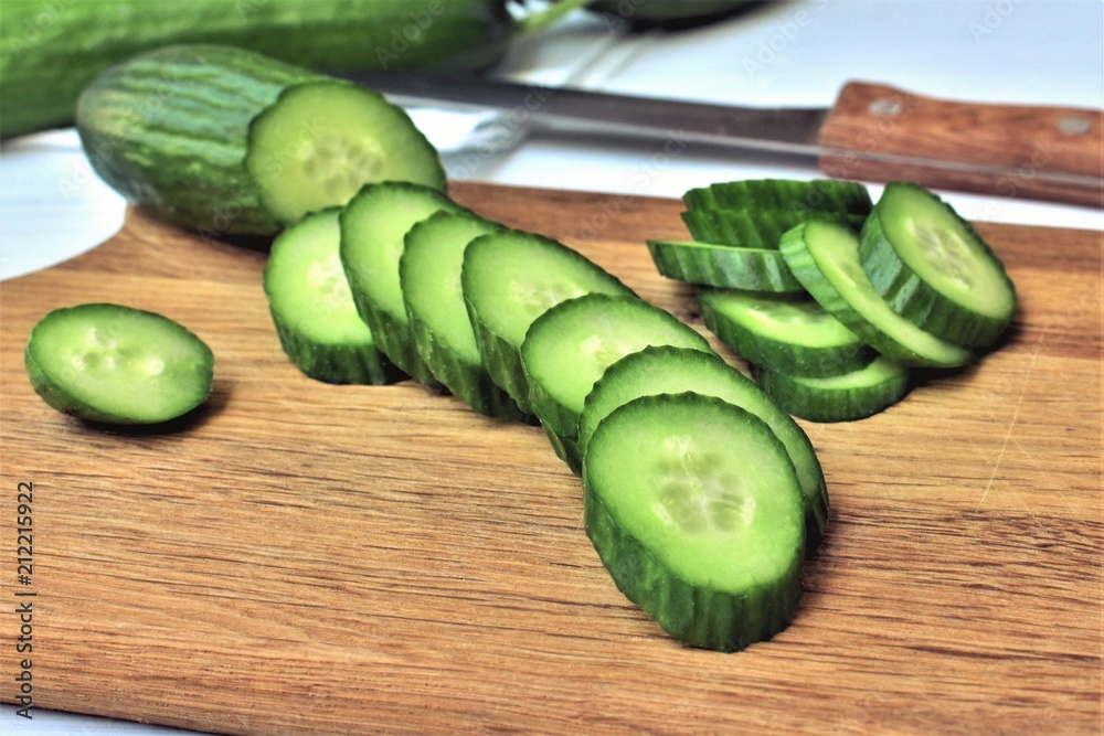 Sliced fresh cucumber on a wooden cutting board. Sliced fresh cucumber on a wooden cutting board.