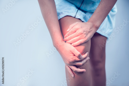 Closeup woman hand holding knee with pain on bed, health care and medical concept