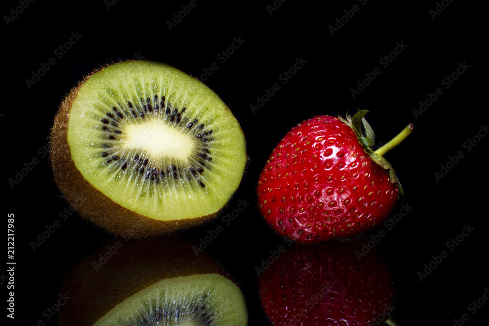 Ripe strawberry with kiwi fruit and reflection on a black background Ripe strawberry with kiwi fruit and reflection on a black background