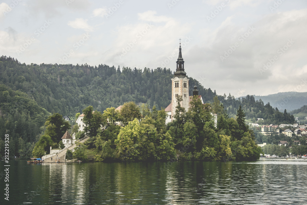 beautiful place called lake bled with church, in slovenia, famous tourist attraction, but too many people and commerce