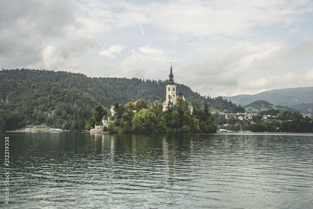 beautiful place called lake bled with church, in slovenia, famous tourist attraction, but too many people and commerce