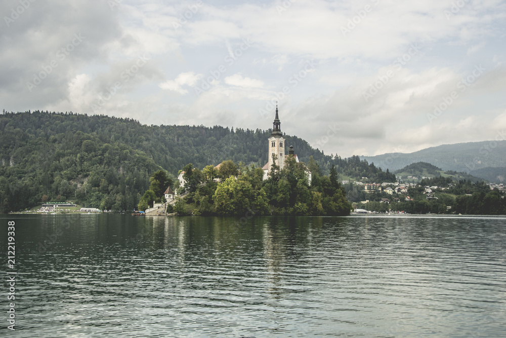 Fototapeta premium beautiful place called lake bled with church, in slovenia, famous tourist attraction, but too many people and commerce