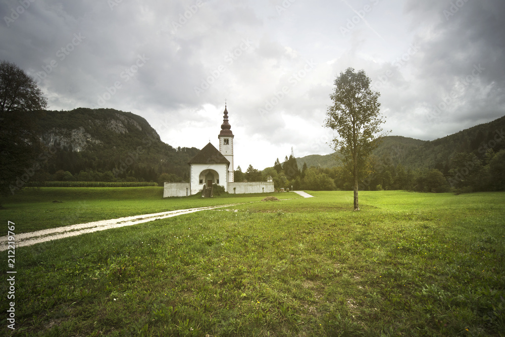 slovenian church in the evening, sun light over the church and the lawn, slovenia state's landmark, typical view for this state slovenian church in the evening, sun light over the church and the lawn, slovenia state's landmark, typical view for this state